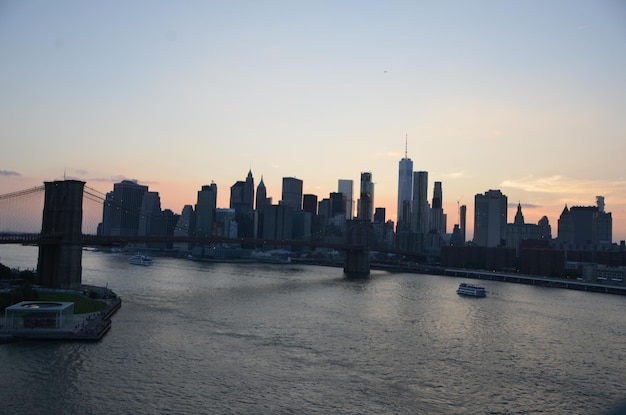 Manhattan skyline over brookyn bridge tegen de hemel tijdens zonsondergang
