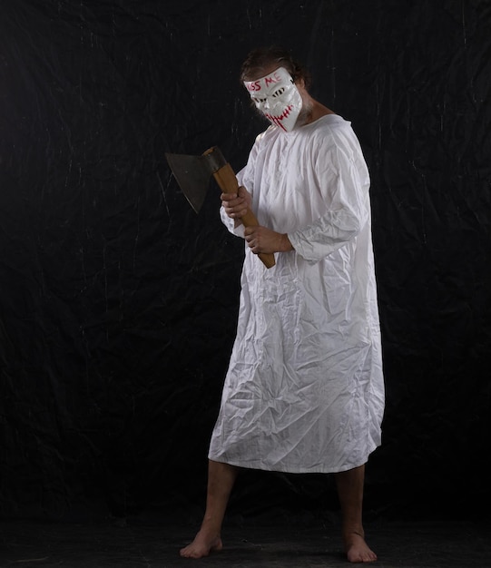 maniac in a hockey mask in a medical gown on a black background