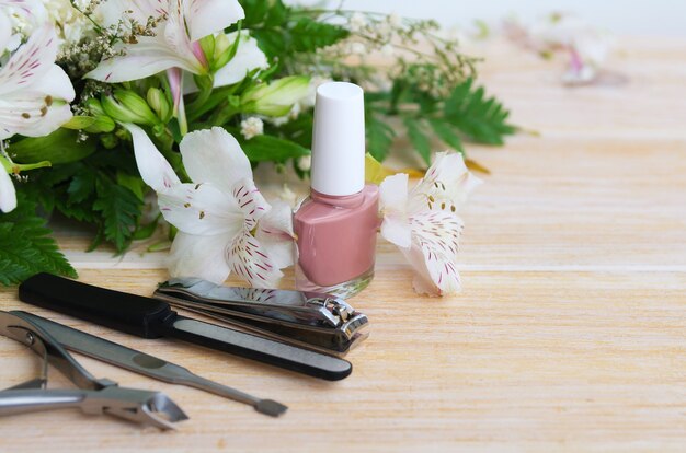 Accessori per manicure: smalto per unghie nudo, limetta per unghie diamantata, dispositivo per rimuovere le cuticole, tagliaunghie e spingi unghie. concetto di manicure a casa. copia spazio.