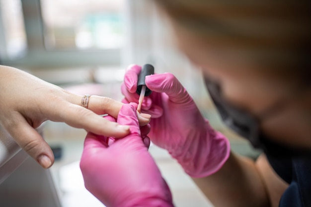 Artista del manicure che fa manicure professionale nel salone di bellezza