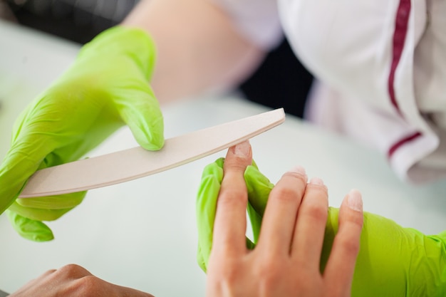 Manicure in proces. Vrouw in een nagelsalon die een manicure ontvangt door een schoonheidsspecialiste