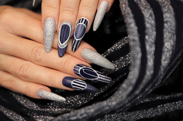 Manicure on long shaped nails with blue and silver top coating