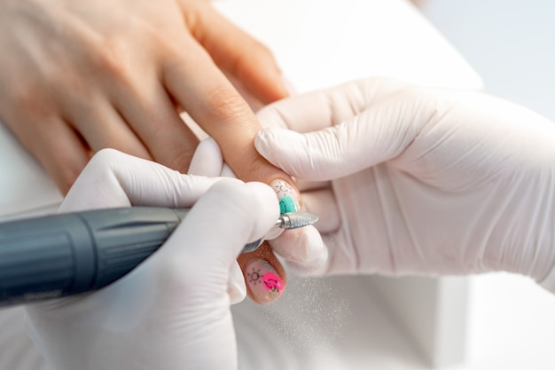 Manicure master uses an electric nail machine