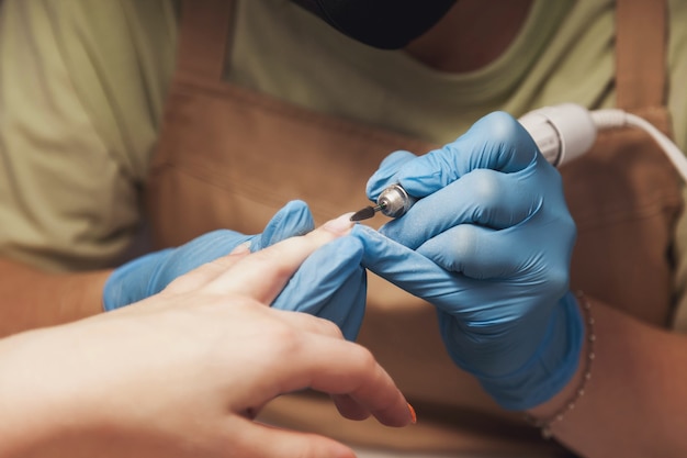 Manicure meester maakt nagels schattige mooie jonge vrouw in schoonheidssalon. Klantenservice in interieursalon om een geweldig beeld te creëren. Wizard voor het maken van werk. Concept van maatregel tevredenheid. Ruimte kopiëren