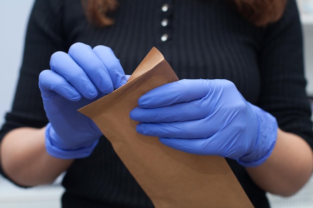 Manicure pakt gesteriliseerd gereedschap uit in handschoenen