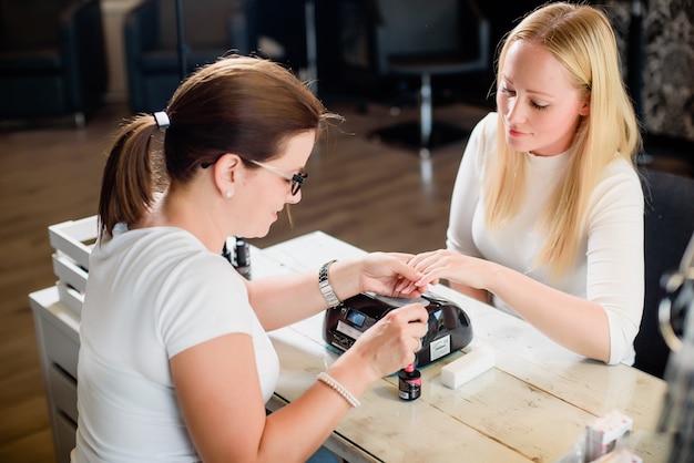 Manicure procedure met de roze nagellak