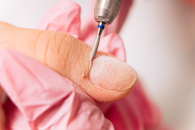 Manicure proces. De meester polijst de nagel met behulp van een geautomatiseerde machine. Boor polish remover.