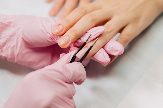 Manicure proces. de meester vormt een kunstnagel van een speciale gel met een pincet.