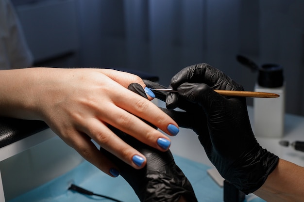 살롱 근접 촬영에 매니큐어 여자는 매니큐어로 손톱을 페인트