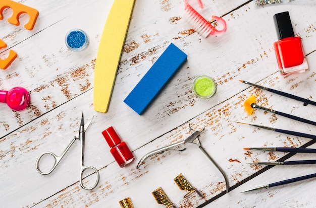 Manicure set and nail polishes on a white wooden background