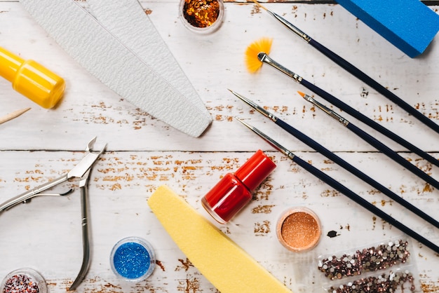 Manicure set and nail polishes on a white wooden background