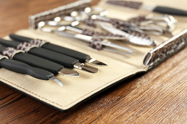 Manicure set in open case on wooden table closeup