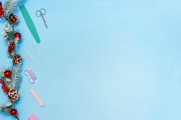 Manicure set with a decorated with balls spruce branch on a blue