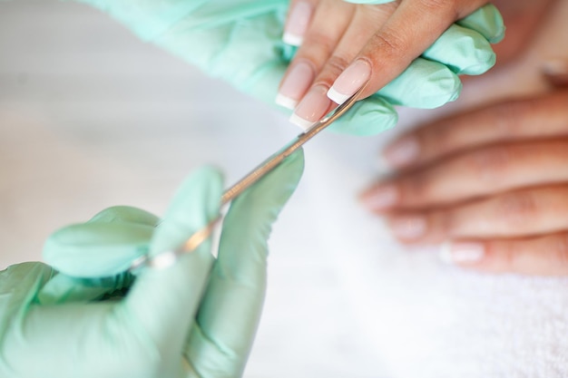 Manicure. Skillful master of manicure holding file in her hands while working in her beauty salon.