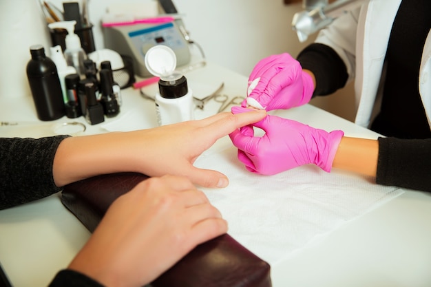 Manicure specialist prepares hands.