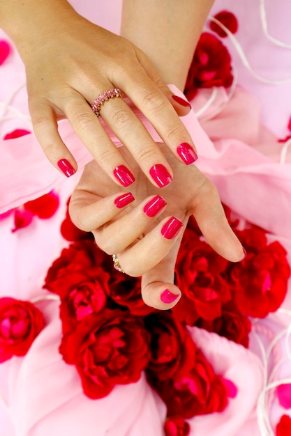 Manicure with red nails and rose petals.