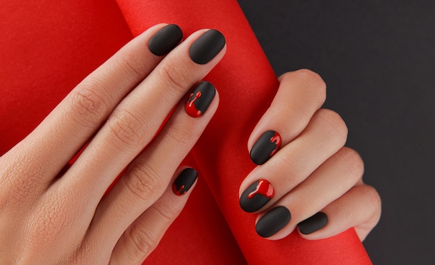 Manicured female hands with fashion accessories trendy autumn halloween bloody spooky nail design