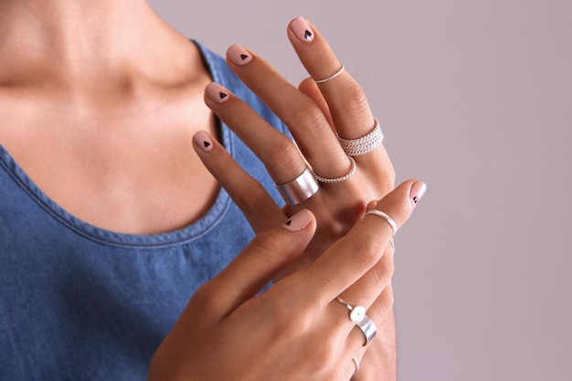 Photo manicured hands with silver rings made with filigree technique