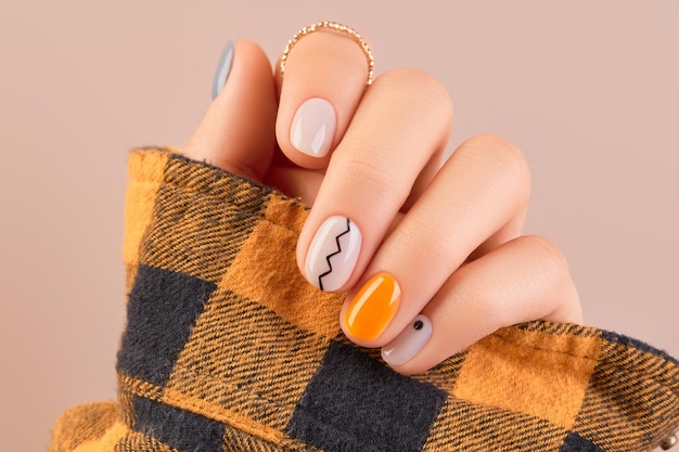 Photo manicured womans hand close up on beige background minimal spring autumn nail design