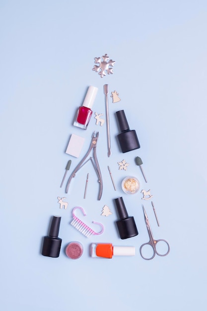 Foto manicuregereedschap en nagellakken liggen in de vorm van een kerstboom