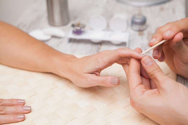 Manicurist cleaning a customers nails