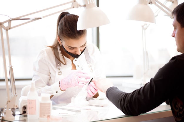 A Manicurist Cutting Off The Cuticle From The Person's Fingers