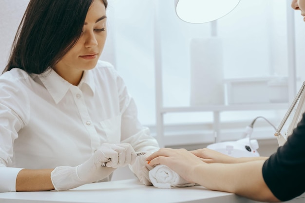 Manicurist does manicure for client