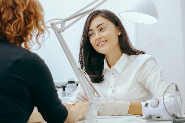 Manicurist does manicure for client