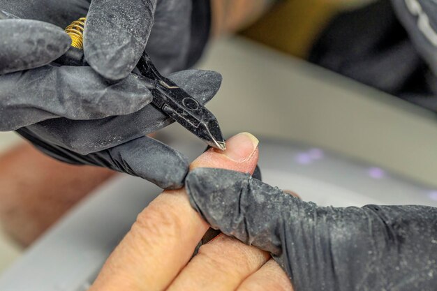 Photo manicurist fixing nails of a client