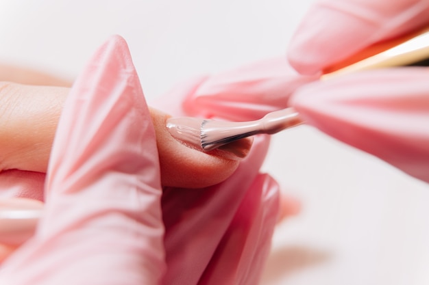 Manicurist paints fingernails