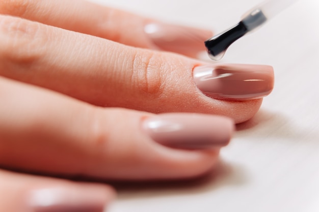 Photo manicurist paints fingernails