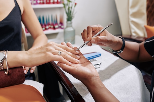 Photo manicurist pushing cuticle