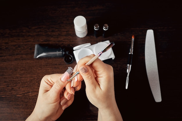 The manicurist treats the nail to herself