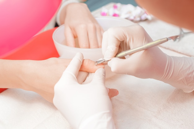 Manicurist uses professional manicure tool.