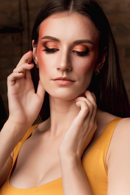 Manierportret van vrij donkerbruin model met lichte make-up bij studio