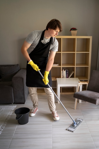 Manlijke bediende die het huis schoonmaakt