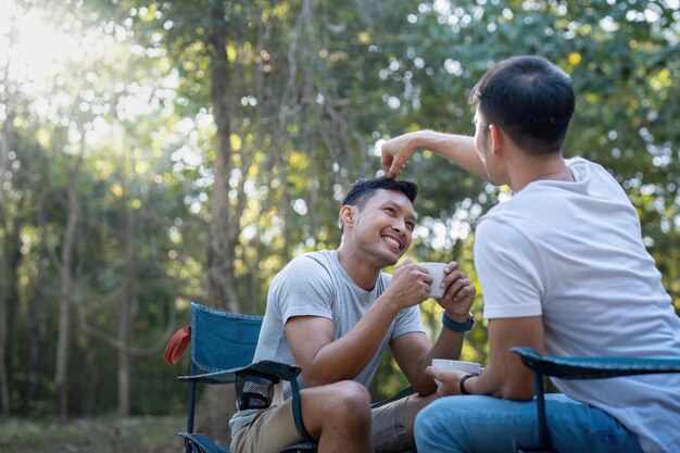 Mannelijk homoseksueel koppel Aziatisch reizen met tent kamperen buiten en verschillende avontuurlijke levensstijl wandelen actieve zomervakantie koffie drinken en samen praten