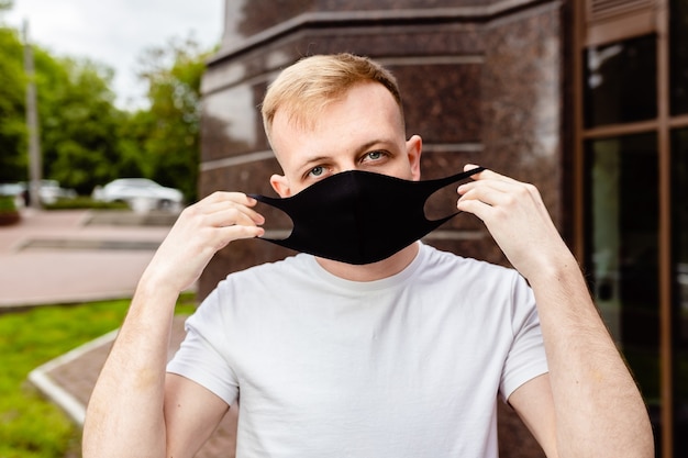 Mannelijk portret. Een man met een zwart masker. Quarantaine in de stad.