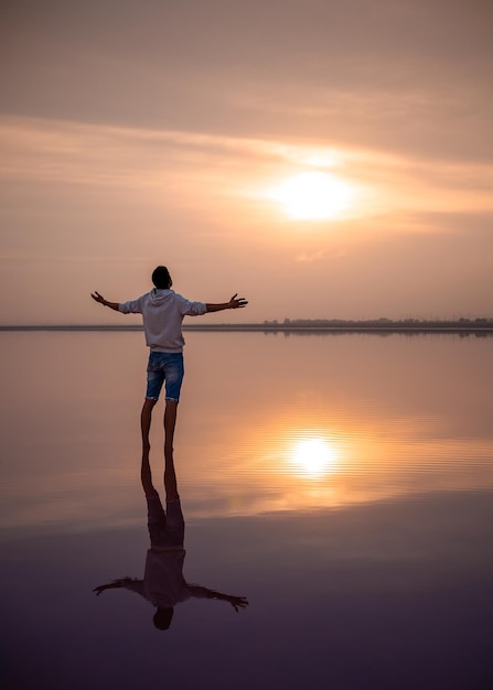 Mannelijk silhouet op het strand Een wandeling bij zonsopgang en meditatie