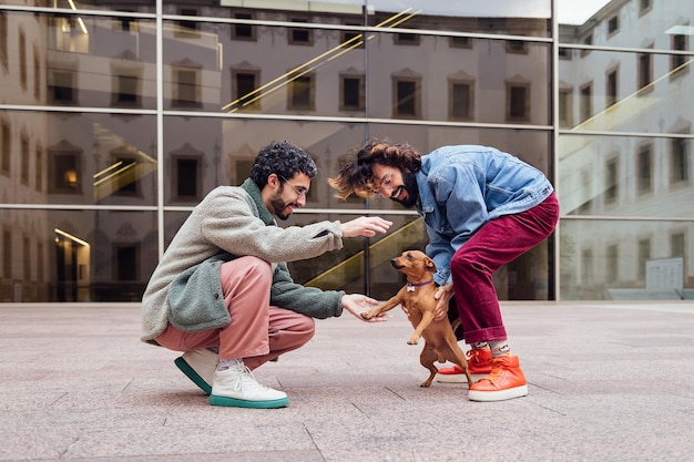 Mannelijk stel speelt met hun ondeugende kleine hond