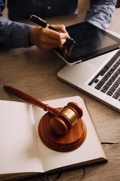 Mannelijke advocaat die werkt met contractpapieren en houten hamer op tafel in rechtszaal Justitie en wetsadvocaat Hofrechter concept