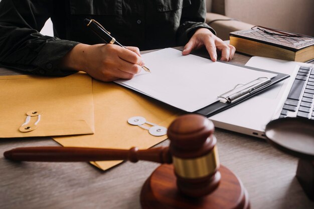 Mannelijke advocaat die werkt met contractpapieren en houten hamer op tafel in rechtszaal Justitie en wetsadvocaat Hofrechter concept