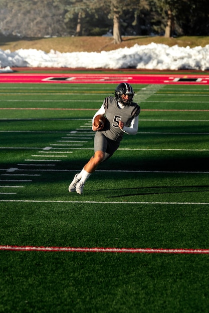 Foto mannelijke american football-speler in uniform op het veld