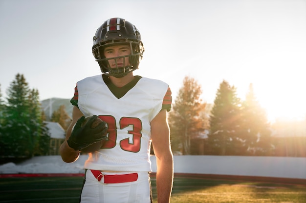 Foto mannelijke american football-speler in uniform op het veld