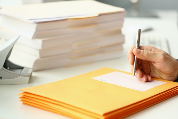 Mannelijke arbeider die collectieve post in bureau voorbereiden