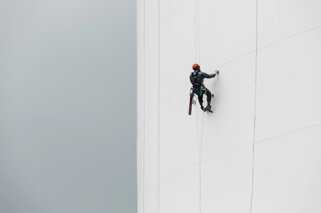 Mannelijke arbeiders controleren de kabel naar beneden in de hoogte van de tank, de toegangscontrole van de dikte van de schaalplaatopslagtank.