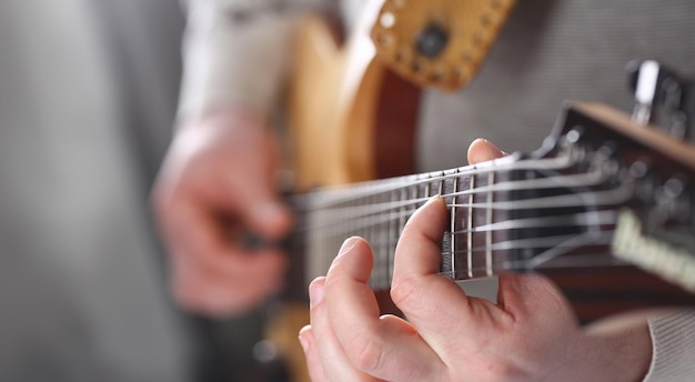 Foto mannelijke armen die klassieke elektrische gitaar spelen