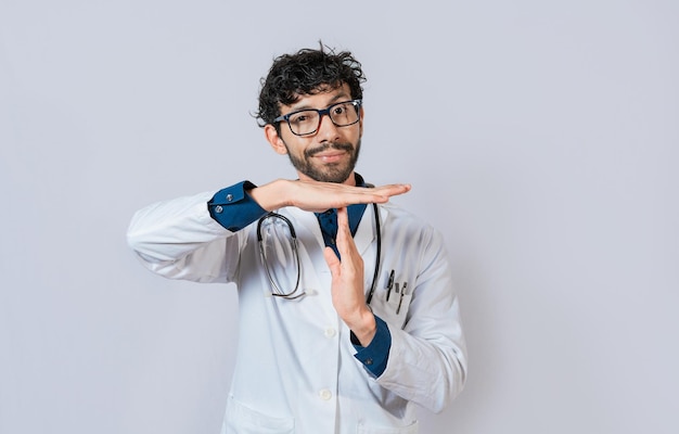 Mannelijke arts die een time-out gebaart Arts die een time-outgebaar maakt met handpalmen op geïsoleerde achtergrond