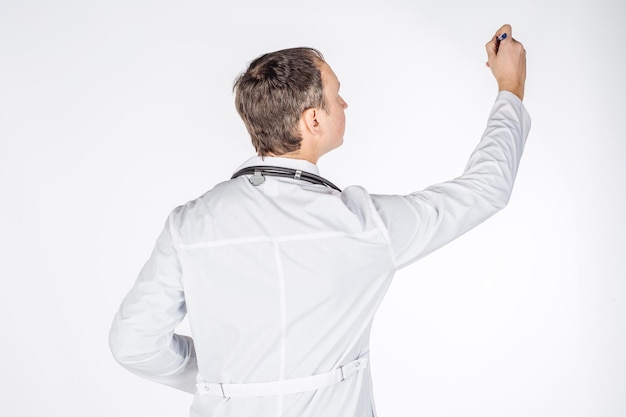 Mannelijke arts in witte jas die iets denkbeeldigs schrijft of tekent met stift