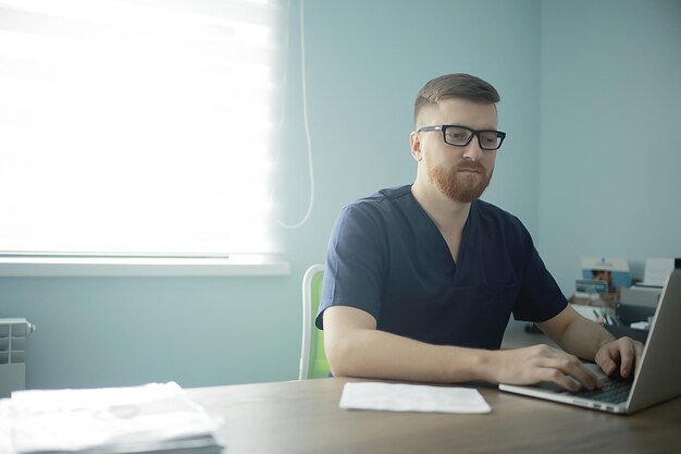 Mannelijke arts / jonge man in mediaan uniform, strikte dokter met bril, medische kliniek